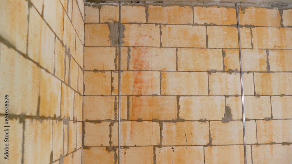 The wall is primed along the beacons before plastering. The wall is