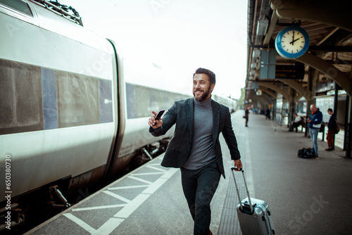 Young Caucasian businessman in a hurry to catch his train at the train station