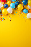 Colorful balloons, confetti and candies on yellow background, birthday party background, greeting card, with space for text