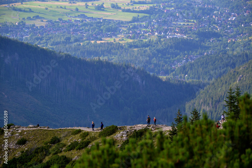 Amidst the breathtaking Tatra Mountains, Poland, hikers traverse scenic trails, immersed in the awe-inspiring beauty of nature's grandeur. With each step, they embrace the serene adventure