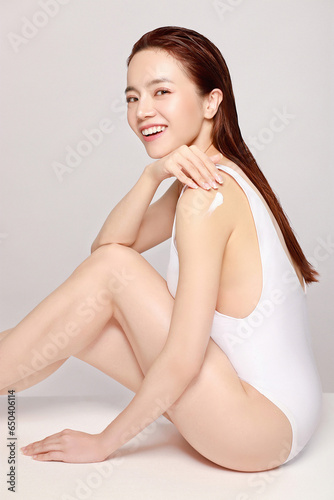 Fotografie, Tablou Beautiful young asian woman with clean fresh skin & body on greay background