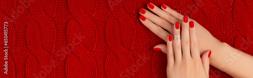 Womans hands with matt manicure on red knitted coverlet. Winter manicure, pedicure design trends