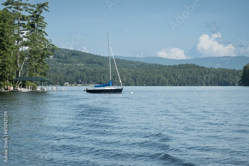 Sailboat on New Hampshire's Lake Winnipesaukee with the White Mountains in the background photo