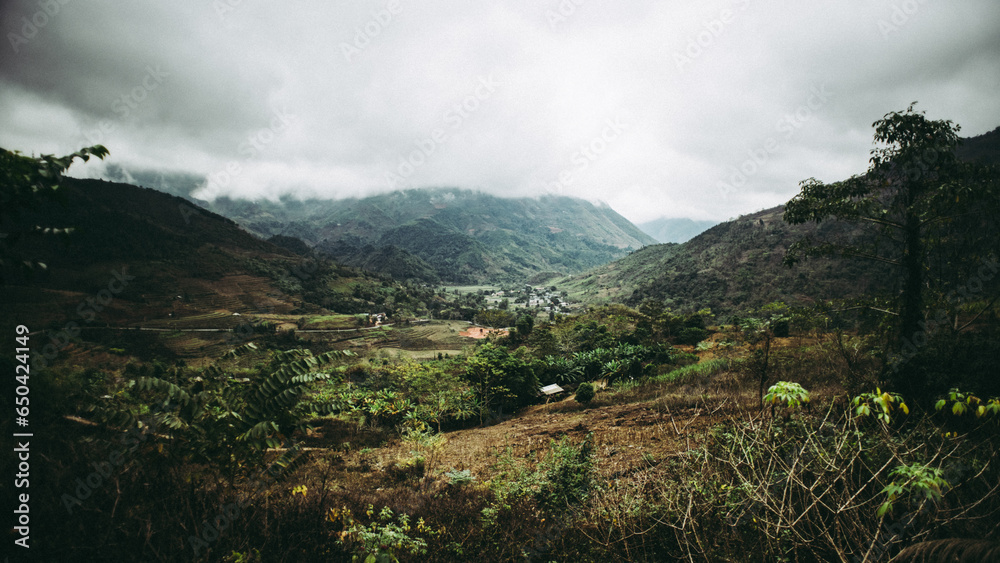 Fototapeta premium Beautiful view of a green landscape with mountains under the cloudy sky
