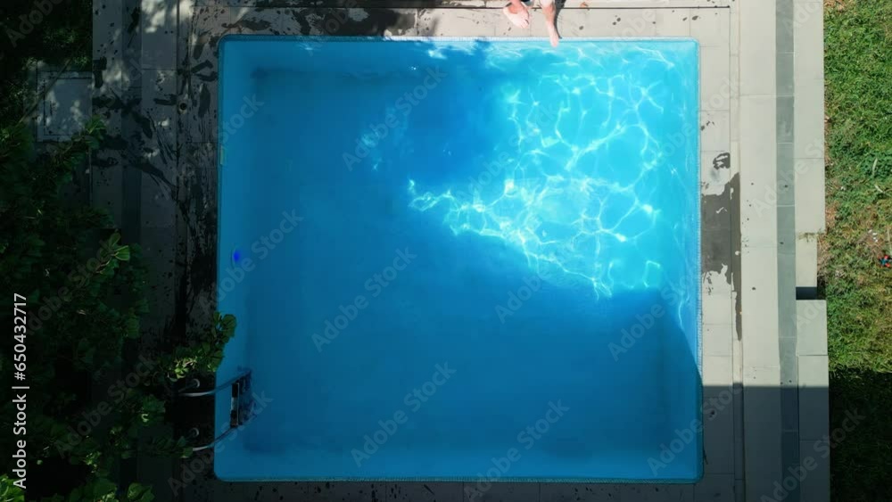 Top view of a swimming pool in the backyard of a house on a hot summer ...
