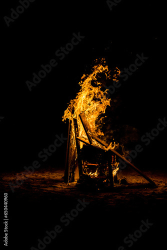 Burning chair with more pieces of wood during the San Juan bonfire festival in Alicante at night