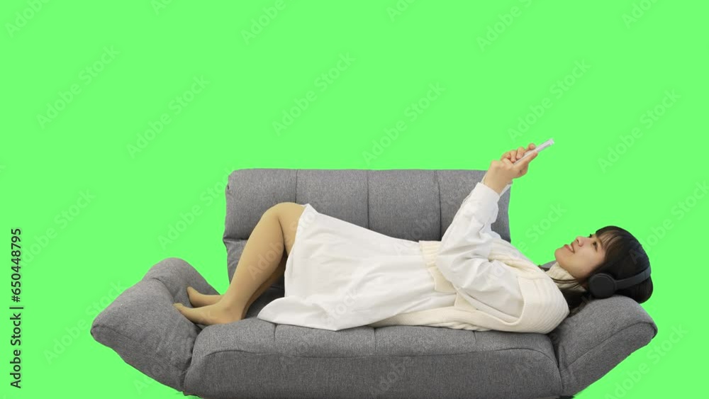 ソファーで寛ぎながらスマートフォンを操作する女性 クロマキー合成素材 ソファーで寛ぎながらスマートフォンを操作する女性 クロマキー合成素材
