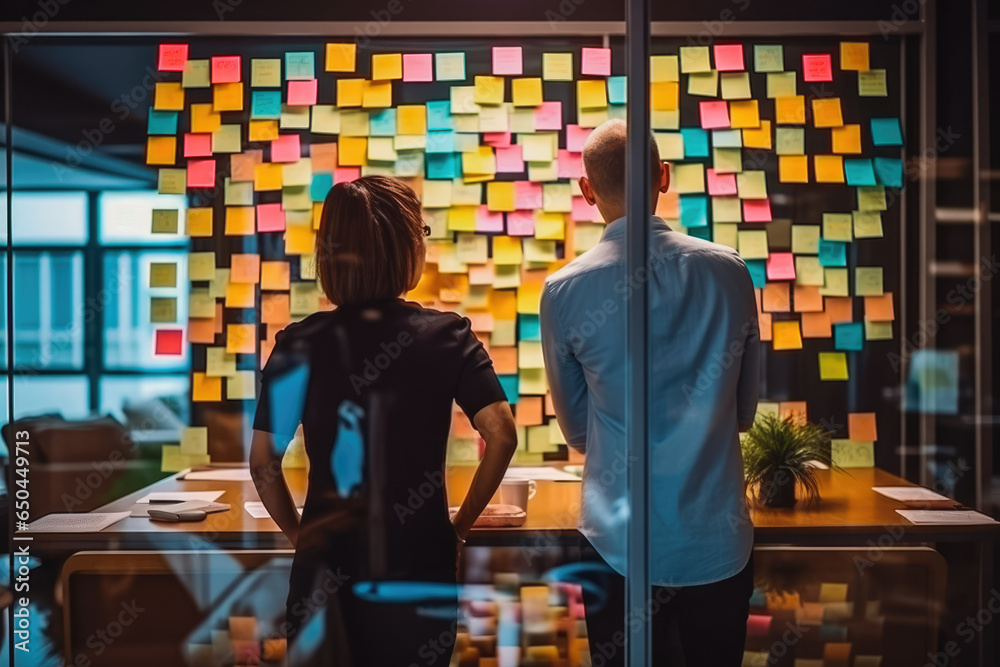 Group of creative people brainstorming ideas with the help of colorful sticky papers, great team work finding solution to a problem