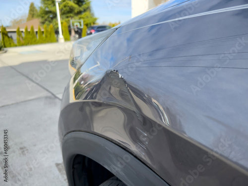 Tableau sur toile Close up view of a dent on the left side of a gray vehicle