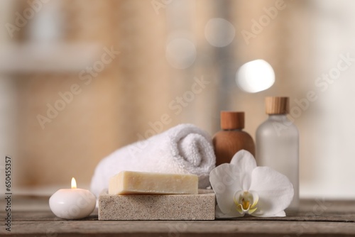 Composition with spa products and beautiful orchid flower on wooden table against blurred background