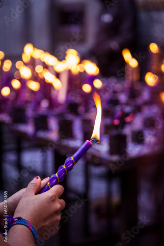 Hand of an unknown person holding a candle with his hand for the festival of the Lord of Miracles in Lima, Peru