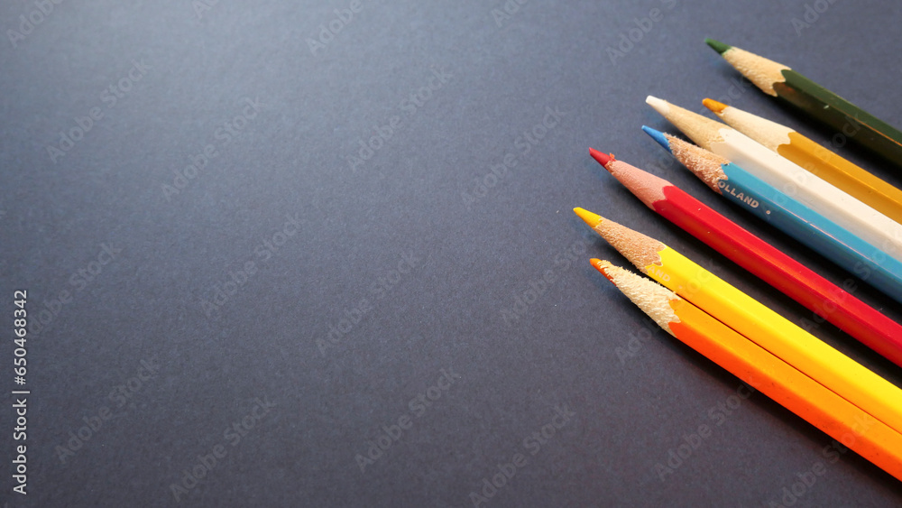 Colored wooden pencils on the dark background Colored wooden pencils on the dark background