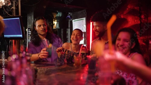 Young and diverse group of friends having a toast while drinking cocktails on their night out in a bar
