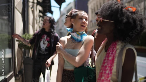 Young and diverse group of friends and tourists shopping and browsing stores in the city while on a vacation