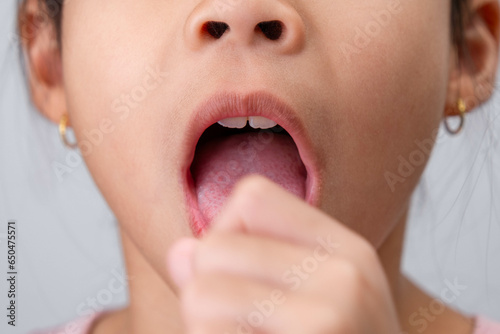 Little girl sick at home. Cute little girl coughing, covering her mouth with her hand while coughing