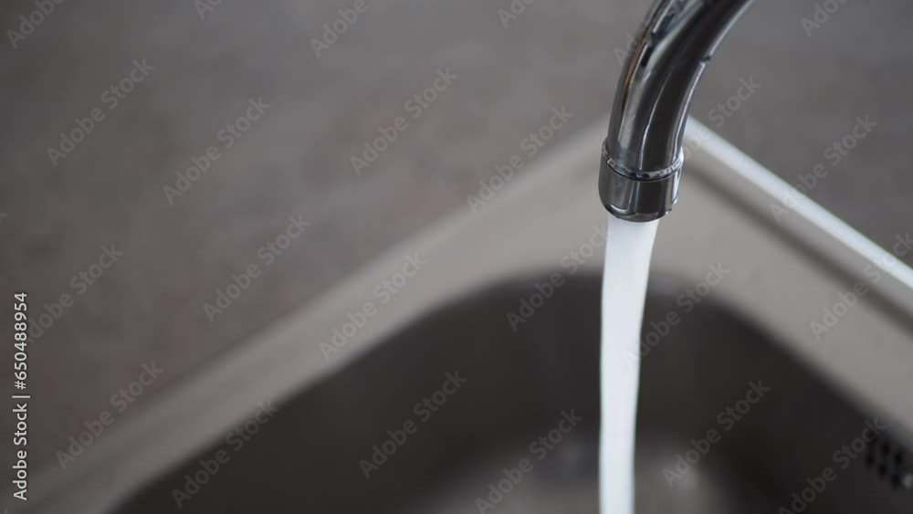 Water dripping from faucet tap at kitchen. Closeup Water dripping from faucet tap at kitchen. Closeup