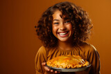 Radiant young girl in festive dress, joyfully holding a homemade pumpkin pie against plain background, symbolizing Thanksgiving warmth, family unity and love.