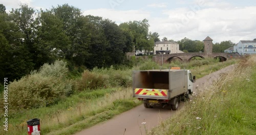 Wide shot of Monnow Bridge next to Monnow river with County council vehicle driving up cycle path photo