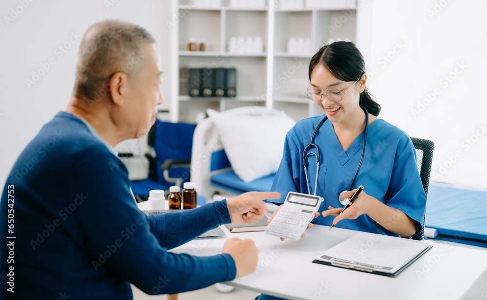 Obraz premium Healthcare costs and fees concept.Hand of smart doctor used a calculator and smartphone, tablet for medical costs at hospital in morning light.