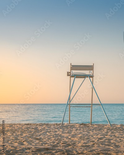 sunrise on beach with lifeguard chair room for text - Beach Lifeguard Security Coastline Safety Concept