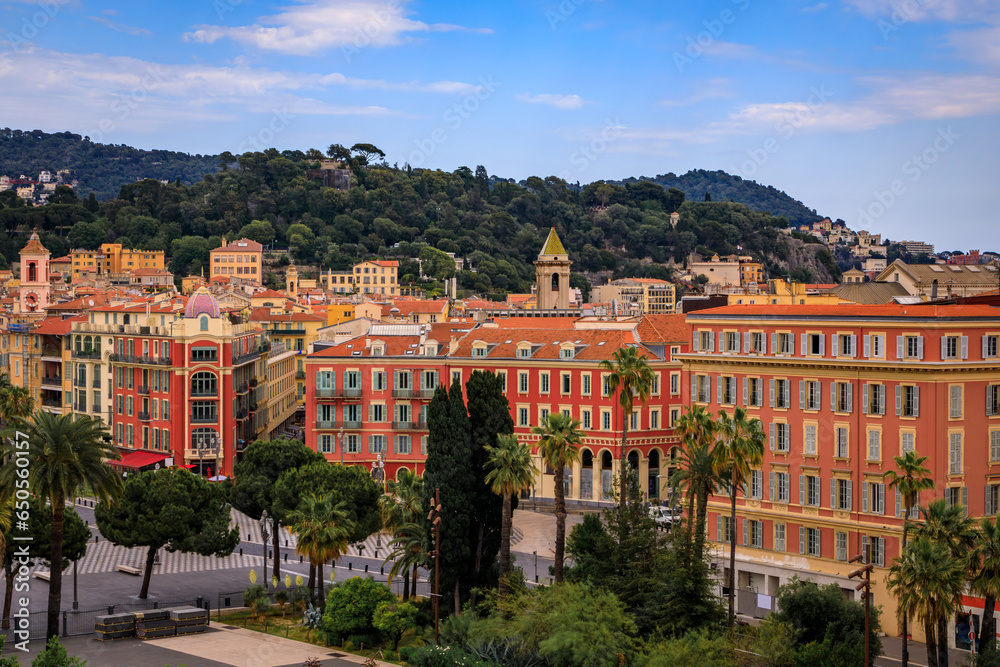 Aerial view of Old Town or Vielle Ville buildings, the trees of Promenade du Paillon and Castle Hill or Colline du Chateau at sunset in Nice, France