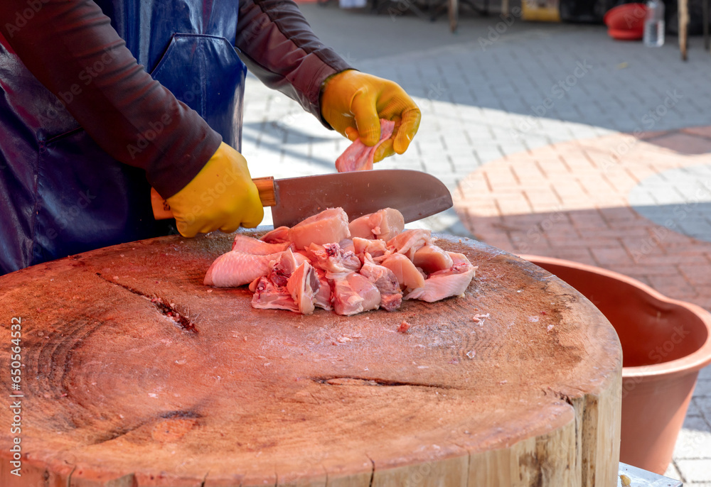 한국 전통시장에서 닭고기를 칼로 자르는 상인의 손 