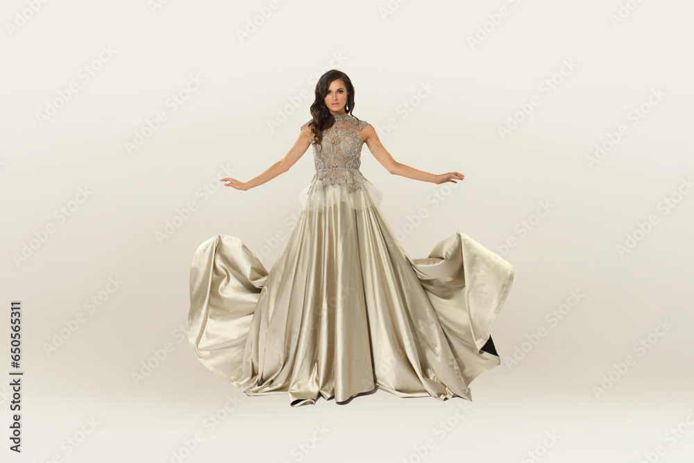 Fototapeta premium Fashion perfect stylish beautiful elegant woman in silver dress on white background. Portrait of attractive female model in studio