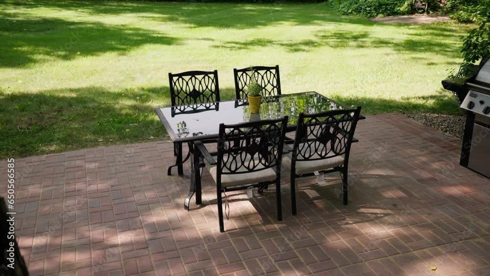 panning reveal shot of an outdoor patio dinner table next to a grill on a sunny day panning reveal shot of an outdoor patio dinner table next to a grill on a sunny day
