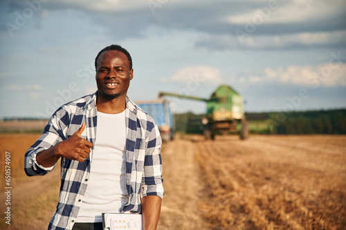 Showing thumb up. Beautiful African American man is in the agricultural field