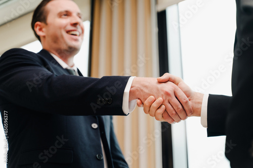 Businessmen shaking hands while standing in an office.