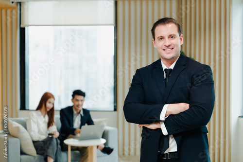 Busniness man smiling with arms crossed in a coworking office.