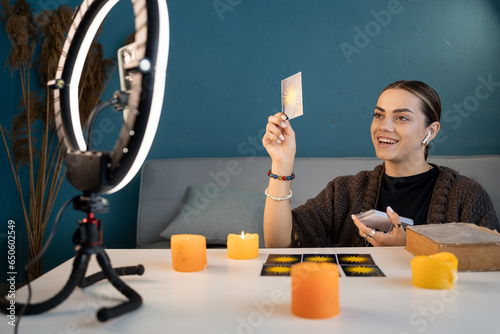 Canvas-taulu Young fortune teller with tarot cards telling fortunes online, blogger astrologe