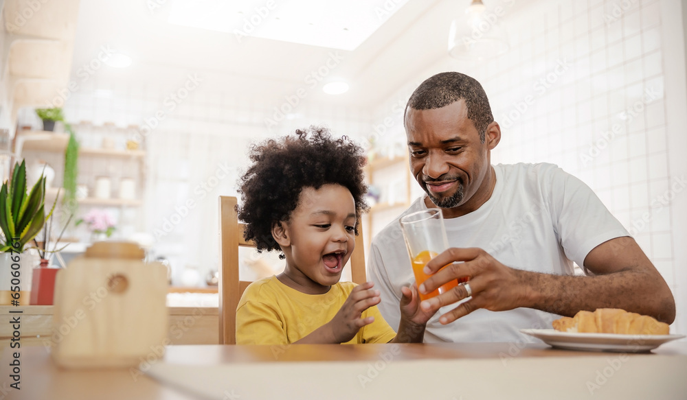 Portrait of happy African american father and son hands drink eat during breakfast time at dining table with copy space. Single dad family love lifestyle, father’s day warm gentle family. - obrazy, fototapety, plakaty 