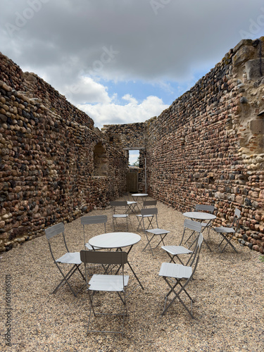 Tables and chairs on a terrace surrounded with stone wall