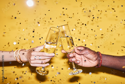 Slika na platnu Closeup of two hands clinking champagne glasses against vibrant yellow backgroun