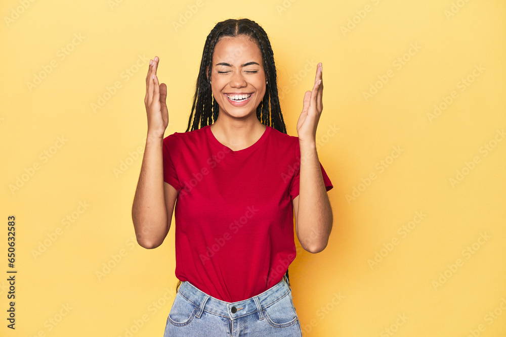 Young Indonesian woman on yellow studio backdrop joyful laughing a lot. Happiness concept. Young Indonesian woman on yellow studio backdrop joyful laughing a lot. Happiness concept.