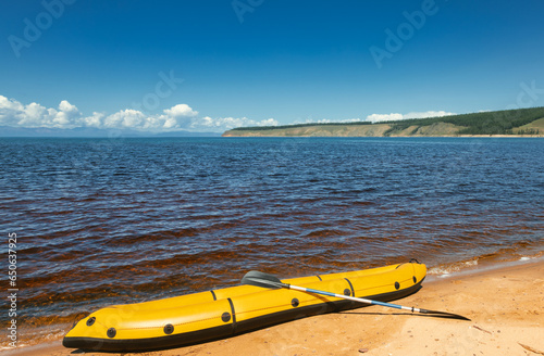 Yellow packraft on a lake shore