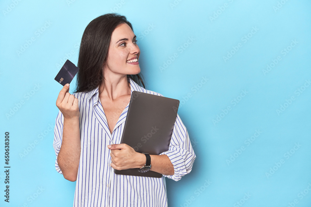 Professional with laptop and credit card on blue Professional with laptop and credit card on blue
