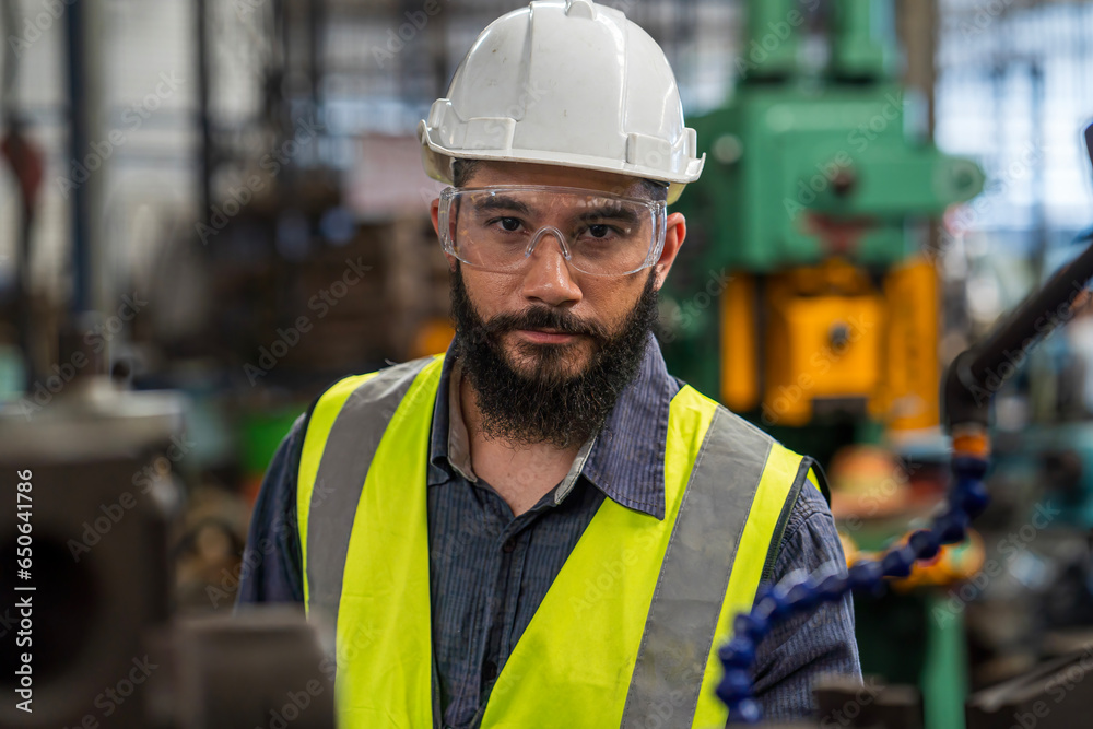 Fototapeta premium The technician is working in a steel factory. The Industrial engineer wearing protective clothing puts on hard hat.