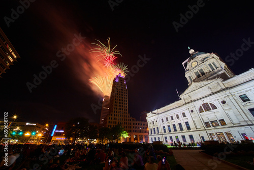 Downtown Fort Wayne courthouse lawn with crowd watching 4th of July fireworks over Lincoln Tower