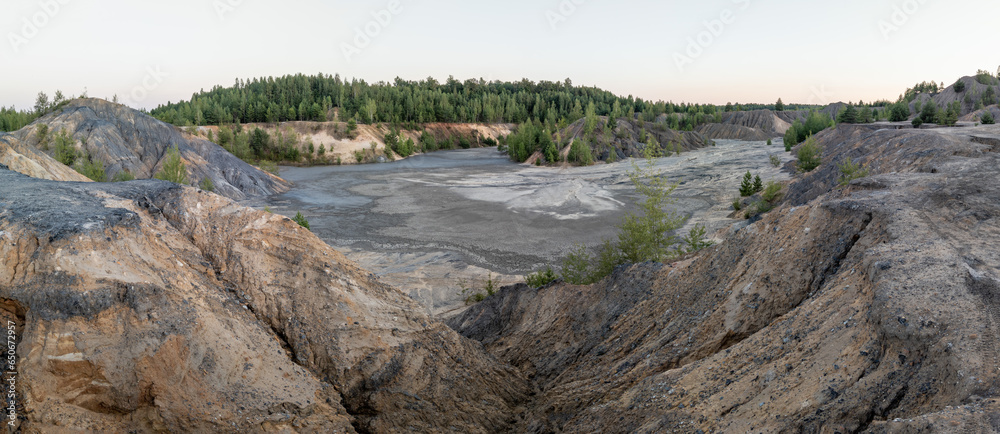 eroded soil quarry ravine with forest on its edge at summer evening panoramic photo. eroded soil quarry ravine with forest on its edge at summer evening panoramic photo.