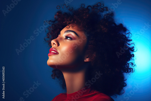 Profile of biracial woman with curly hair in blue and red light