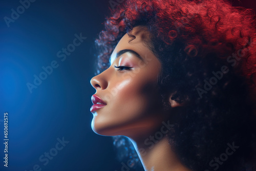 Profile of biracial woman with curly hair in blue and red light