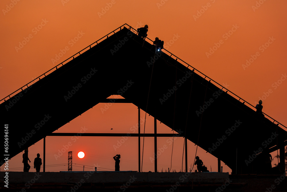Construction and worker at sunset