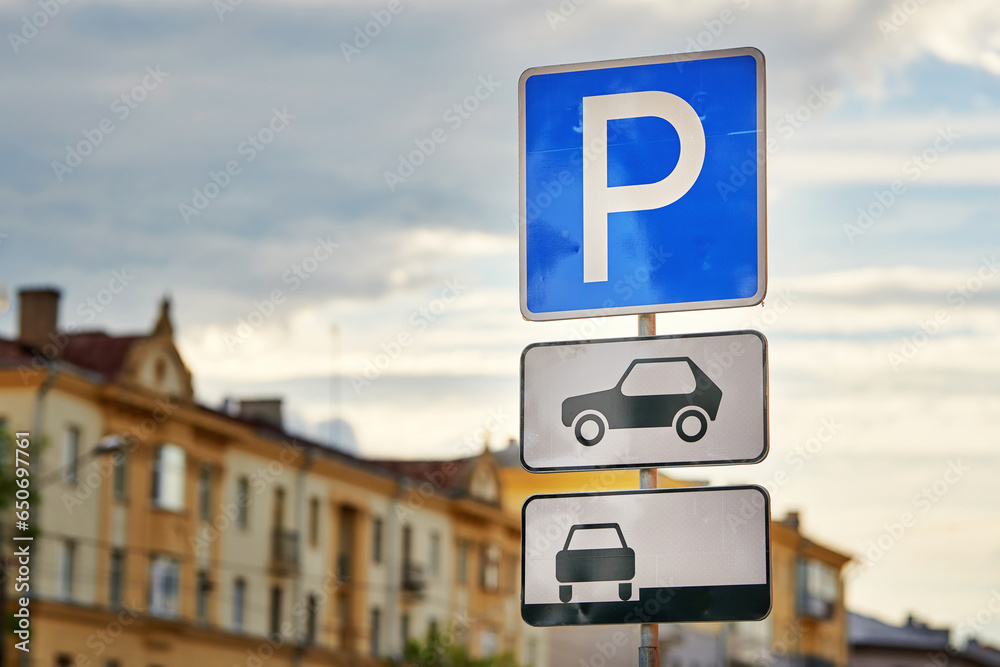 Road sign - Parking sign in the city. Parking zone for cars. Parking sign, city on background Road sign - Parking sign in the city. Parking zone for cars. Parking sign, city on background
