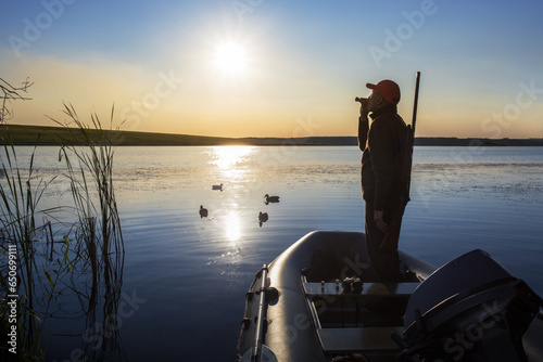 Hunter calling ducks at lake. duck hunter. photo