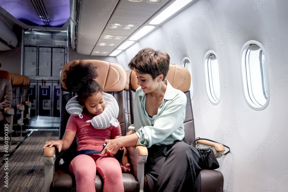 Parent take care kid on airplane, mother teach daughter to use seat