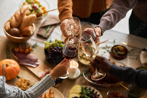 Canvas Print Multiethnic group of friends at festive dinner table celebrating Thanksgiving to