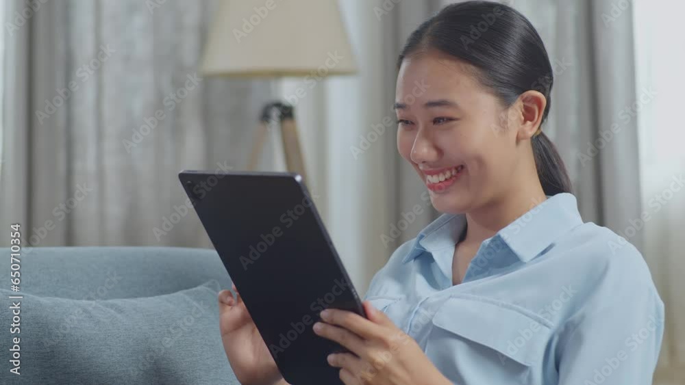 Close Up Of Asian Woman Enjoys Using A Tablet While Lying On Sofa In The Living Room
Close Up Of Asian Woman Enjoys Using A Tablet While Lying On Sofa In The Living Room