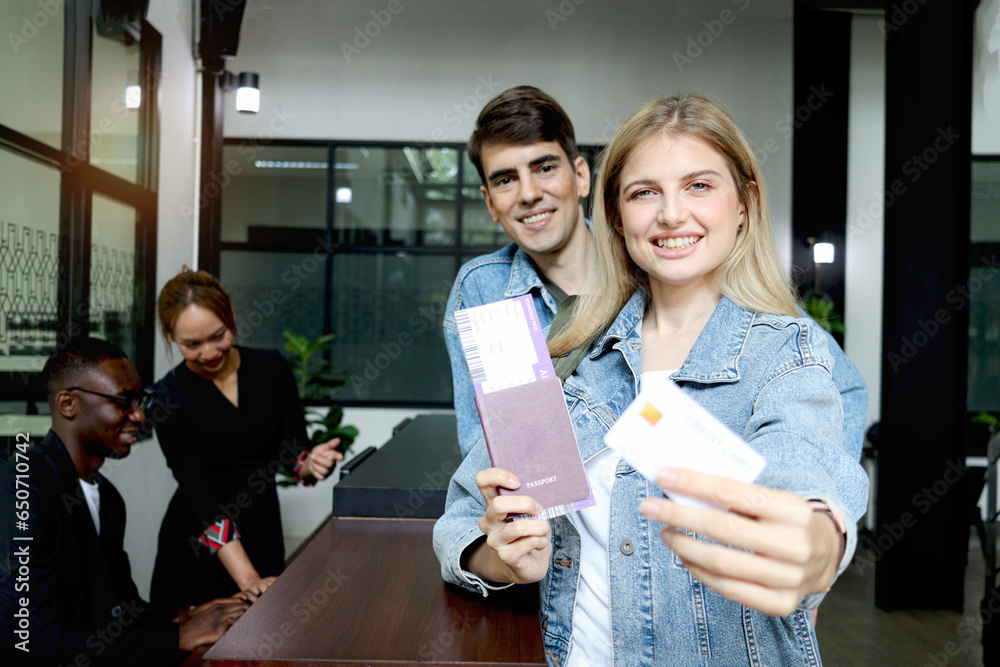 Beautiful woman traveler with long blonde hair shows credit card, holds ...